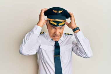 Yakışıklı, orta yaşlı, uçak pilotu üniforması giyen çaresiz ve stresli bir adam. Çünkü acı ve migren ağrısı var. Eller başının üstünde.. 