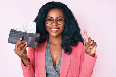 Dolarlarla dolu cüzdanı olan güzel Afrikalı bir kadın bir fikre ya da soru işaretine şaşırmış ve mutlu bir yüzle işaret ediyor. 