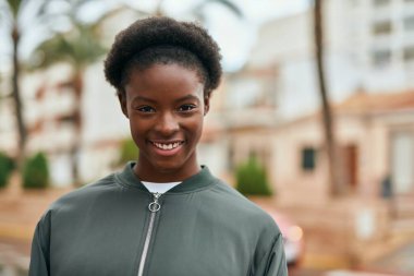 Genç Afrikalı Amerikalı kız parkta mutlu bir şekilde dikiliyor..