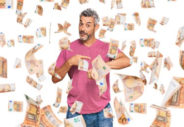 Orta yaşlı, gri saçlı, günlük kıyafetler giyen, acele eden bir adam zamanı, sabırsızlığı ve gecikmeyi işaret ediyor.