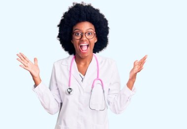 Genç Afro-Amerikalı kadın doktor önlüğü ve steteskop giyip çılgınlığı kutluyor ve kollarını kaldırıp heyecanla haykırarak başarıya hayret ediyor. Kazanan konsept 
