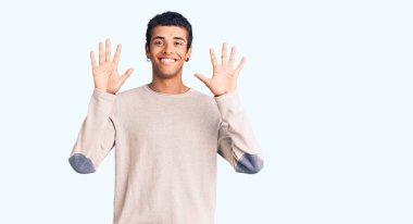 Genç Afrikalı Amerikalı günlük kıyafetler giymiş on numarayı gösterip işaret ederken kendinden emin ve mutlu gülümsüyor.. 