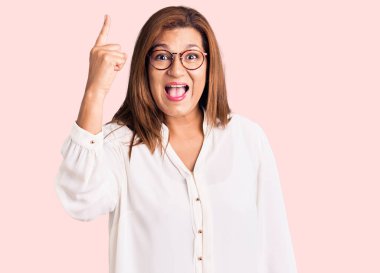 Orta yaşlı, güzel, gözlüklü bir kadın. Kafasını kaldırıp parmağıyla işaret ediyor..