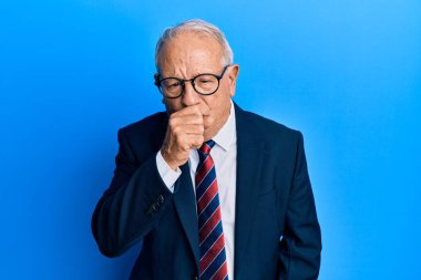 İş elbisesi ve kravat takan kıdemli beyaz adam kendini iyi hissetmiyor ve soğuk algınlığı veya bronşitin belirtisi olarak öksürüyor. sağlık hizmeti kavramı. 