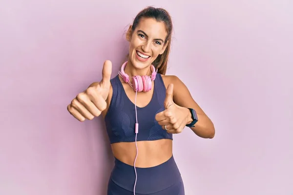Young Beautiful Woman Wearing Gym Clothes Using Headphones Approving Doing — Stock Photo, Image