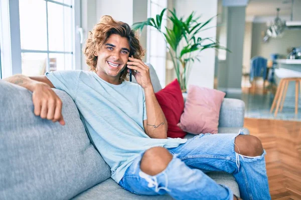 Joven Hombre Hispano Sonriendo Feliz Hablando Teléfono Inteligente Casa —  Fotos de Stock