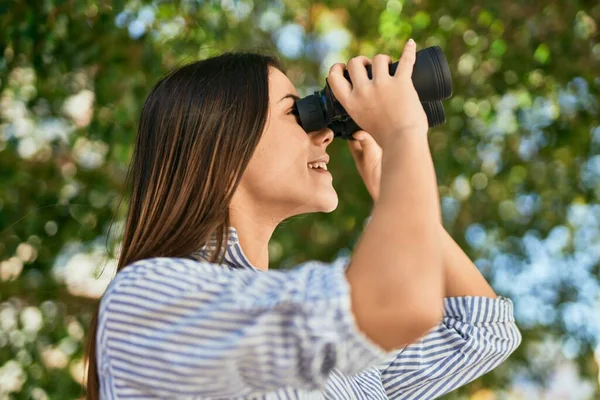 年轻的惊慌失措的女孩在公园用双筒望远镜开心地微笑着 — 图库照片
