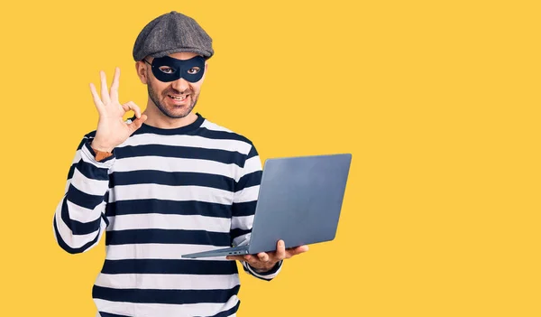 Ung Stilig Man Bär Inbrottstjuv Mask Med Laptop Gör Tecken — Stockfoto