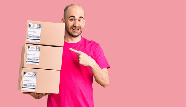 Genç Yakışıklı Adam Teslimat Paketini Tutuyor Gülümsüyor Mutlu Parmaklarıyla Işaret — Stok fotoğraf