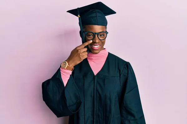 Νεαρή Αφροαμερικανή Που Φοράει Καπέλο Αποφοίτησης Και Επίσημη Ρόμπα Δείχνοντας — Φωτογραφία Αρχείου