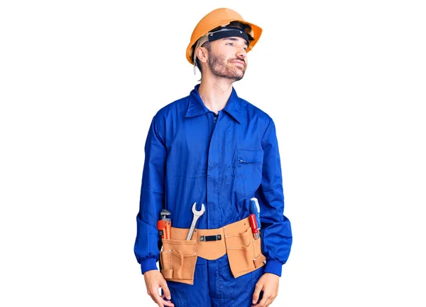 Ung Latinamerikan Man Klädd Arbetare Uniform Leende Tittar Sidan Och — Stockfoto