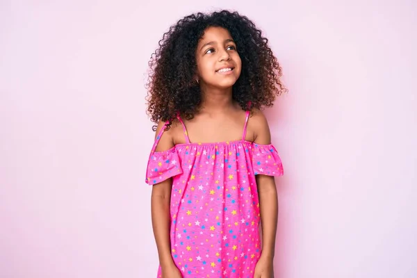 顔に笑顔で横に離れて見てカジュアルなドレスを着て巻き毛を持つアフリカ系アメリカ人の子供 自然な表情 自信を持って — ストック写真
