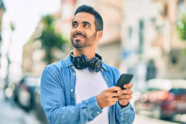 Молодий Іспаномовний Чоловік Посміхається Щасливим Використовуючи Смартфон Навушники Місті — стокове фото