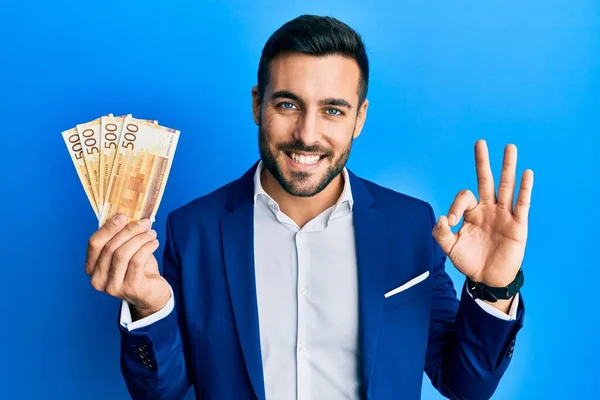 Young Hispanic Businessman Wearing Business Suit Holding Norwegian Krone Banknotes — Stock Photo, Image