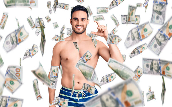 Молодой красивый мужчина в купальниках улыбается и уверенно жестикулирует рукой, делая вывеску небольшого размера с пальцами, смотрящими в камеру. концепция измерения.