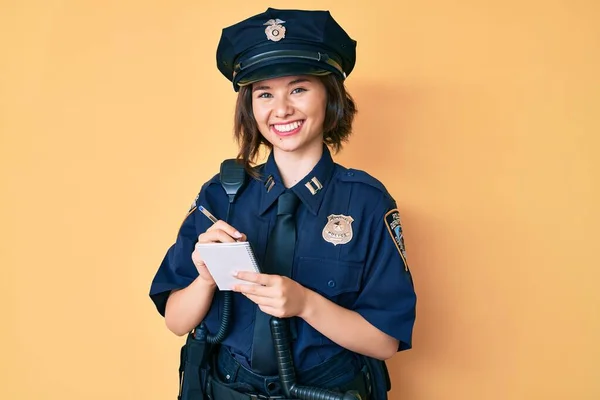 顔に幸せとクールな笑顔で交通罰金笑顔を書いて警察の制服を着て若い美しい女の子 歯を見せて — ストック写真