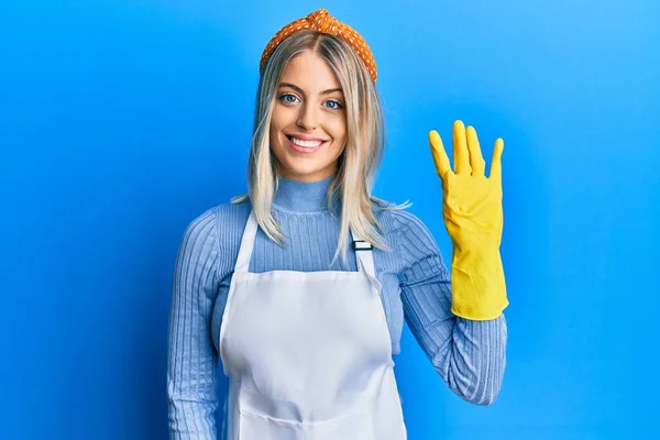 Piękna Blondynka Ubrana Czystszy Fartuch Rękawiczki Pokazujące Wskazujące Palcami Numer — Zdjęcie stockowe