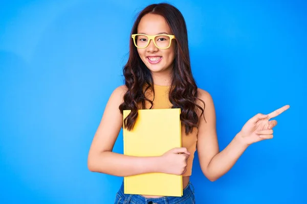 Menina Chinesa Bonita Nova Usando Óculos Segurando Livro Sorrindo Feliz — Fotografia de Stock