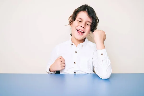 Roztomilé Hispánské Dítě Nosí Ležérní Oblečení Sedí Stole Slaví Překvapení — Stock fotografie