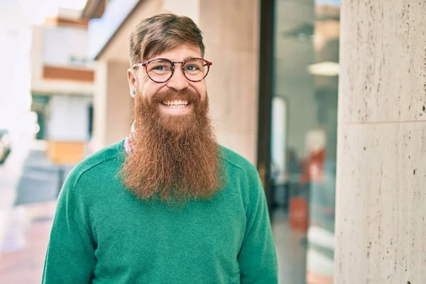 Young irish man with redhead beard smiling happy walking at the city.
