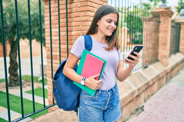 大学構内でスマホを使った本を持っている中近東の女子大生 — ストック写真