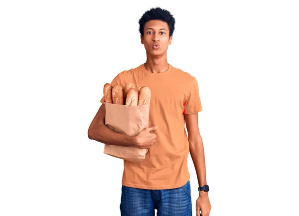 Joven Afroamericano Hombre Sosteniendo Bolsa Papel Con Pan Mirando Cámara —  Fotos de Stock