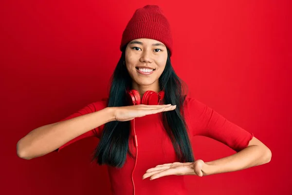 Mladá Číňanka Která Poslouchá Hudbu Pomocí Sluchátek Gestikuluje Rukama Ukazujícíma — Stock fotografie