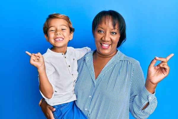 母と息子のヒスパニック系の家族一緒に抱擁で愛笑顔幸せなポインティングとともに手と指で側面 — ストック写真