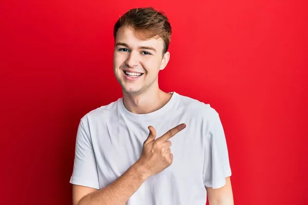 Junger Kaukasischer Mann Lässigem Weißem Shirt Lächelt Fröhlich Und Zeigt — Stockfoto