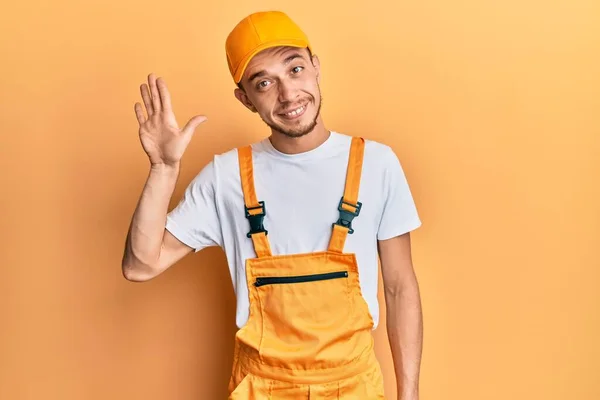 Hispanic Ung Man Bär Händig Uniform Avstå Säga Hej Glad — Stockfoto