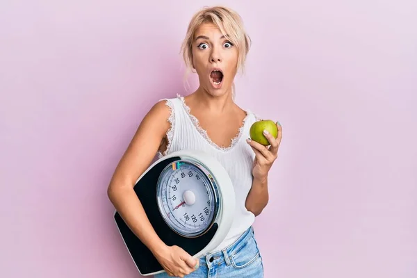 Ung Blond Flicka Som Håller Vikt Maskin Och Grönt Äpple — Stockfoto