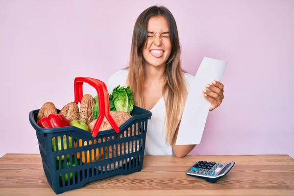 Beautiful Caucasian Woman Holding Supermarket Basket Groceries List Sticking Tongue — Stock Photo, Image