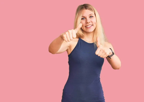 年轻美丽的金发女人穿着休闲装 赞成用手做一个积极的手势 微笑着竖起大拇指 为成功感到高兴 优胜手势 — 图库照片