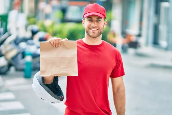 Jovem Entregador Caucasiano Sorrindo Feliz Segurando Saco Papel Entrega Cidade — Fotografia de Stock