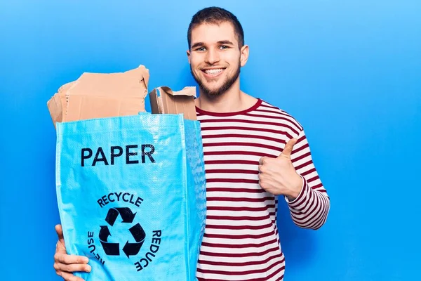 Jovem Homem Bonito Reciclando Papel Sorrindo Feliz Positivo Polegar Para — Fotografia de Stock