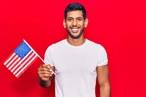 Ung Latin Man Håller Usa Flagga Ser Positiv Och Glad — Stockfoto