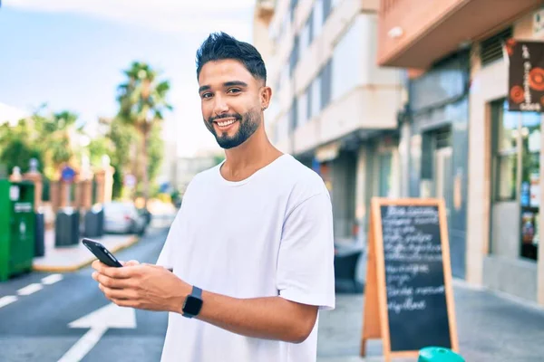 Hombre Árabe Joven Sonriendo Feliz Usando Teléfono Inteligente Ciudad —  Fotos de Stock