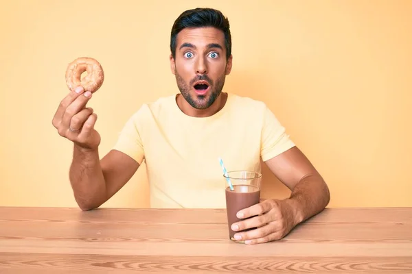 Junger Hispanischer Mann Sitzt Tisch Und Trinkt Schokoladengetränk Hält Donut — Stockfoto
