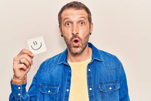 Joven Hombre Guapo Sosteniendo Sonrisa Emoji Recordatorio Asustado Sorprendido Con —  Fotos de Stock