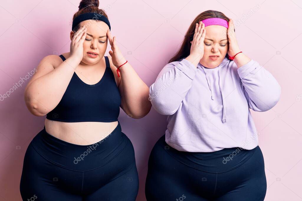 Young plus size twins wearing sportswear with hand on head for pain in head because stress. suffering migraine. 