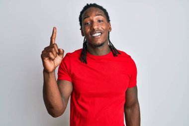 Saçları örgülü, sıradan giyinmiş, başarılı bir fikri işaret eden Afrikalı Amerikalı bir adam. Heyecanlı ve mutlu. Bir numara.. 