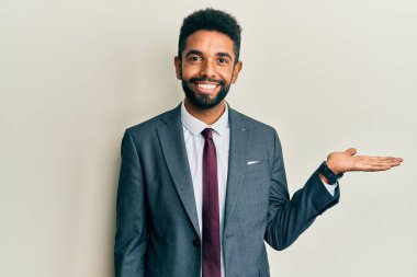 Yakışıklı, sakallı, takım elbiseli, kravatlı, neşeli gülümseyen, eli avucunda kameraya bakan bir İspanyol.. 