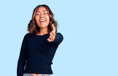 Genç, güzel, melez bir kadın günlük kıyafetler giyiyor. Gülümsüyor, dostça tokalaşıyor ve selamlıyor. başarılı iş. 