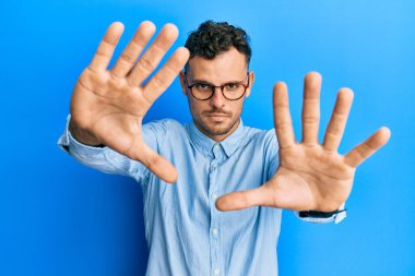 Gündelik kıyafetler giyen ve gözlük takan, el ve parmaklarını kullanarak çerçeve yapan genç İspanyol adam, kamera bakış açısı. 