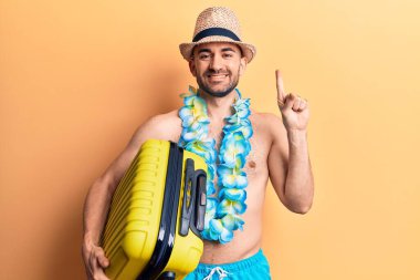 Mayolu yakışıklı kel bir adam ve elinde kamara çantasıyla gülümseyen bir fikir ya da soruyla gülümseyen bir adam. 