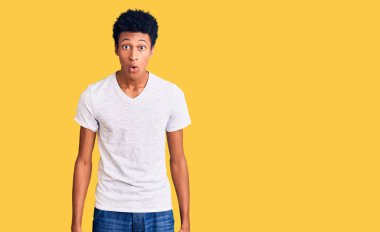 Gündelik beyaz tişört giyen Afro-Amerikalı genç adam ağzı açık kalmış, korkmuş ve hayrete düşmüştü. 