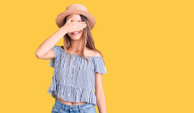 Şapka ve tişört giyen genç ve güzel bir kız. Gülümsüyor ve gülümsüyor. Gözleri şaşkınlıktan kapatıyordu. kör kavram. 