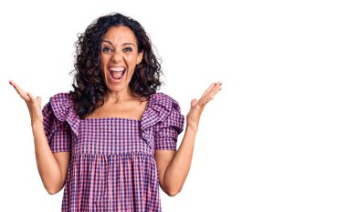 Orta yaşlı güzel kadın gündelik elbiseler giyip zaferi mutlu bir gülümsemeyle kutluyor ve kazanan yüz ifadesi kaldırıyor. 