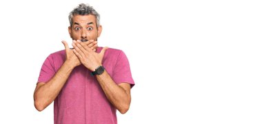 Orta yaşlı, gri saçlı, günlük kıyafetler giyen bir adam ağzı yanlışlıkla ellerle kapatırken şok geçirdi. gizli kavram. 