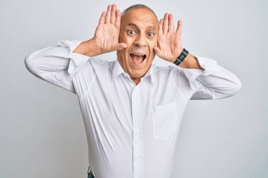 Yakışıklı, beyaz tişört giyen, neşeli gülümseyen, elleri yüzünü gösteren yakışıklı bir adam. Şaşırdım ve çıktım. 